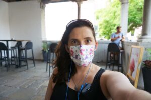 Gigi Griffis sits in a cafe facing the camera in a mask