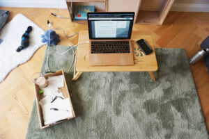 Workspace on the floor with laptop and papers